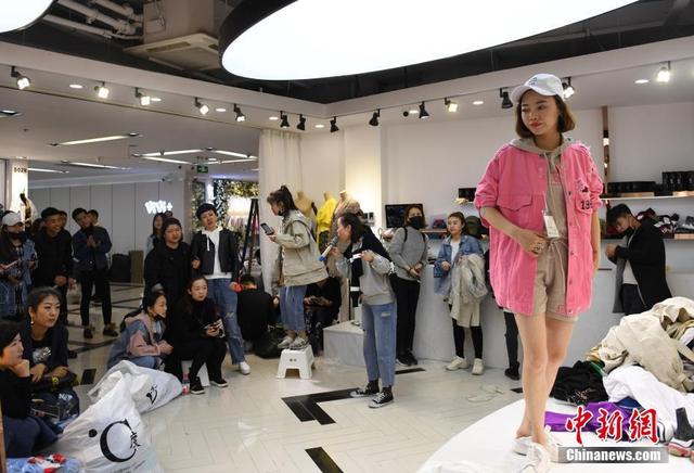在浙江杭州四季青服装市场,不少商铺的"穿版模特"会在店铺搭台试穿