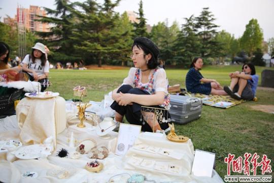 6月18日,中央美术学院毕业季跳蚤市场上,来自杭州的设计师王滨谢在她的手工首饰摊前。今年她两次参加大学的毕业跳蚤市场,她说,这里的销售额可能比不上其他市集,但能感受久违的校园时光。中国青年报·中国青年网见习记者 曲俊燕/摄