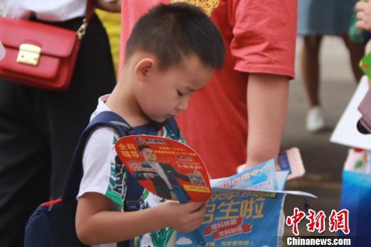 资料图:校外培训机构在学校门口蹲守发广告。 罗鹏 摄