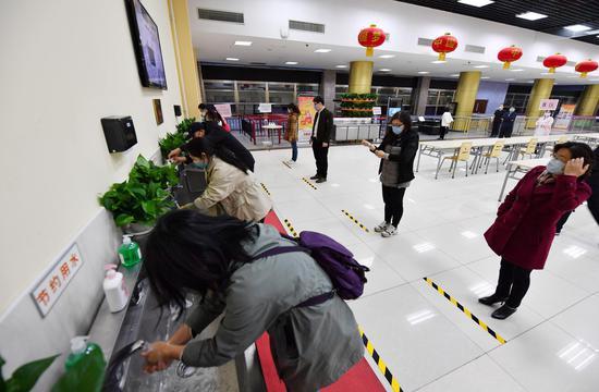 午餐版块工作人员引导“学生”严格按照七步洗手法洗手消毒,按照指示路线保持一米距离有序排队取餐。