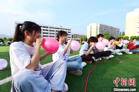 4月13日,江西省赣州市会昌县第三中学高三学生通过合力吹气球进行减压。 朱海鹏 摄