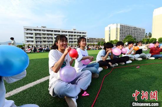 4月13日,江西省赣州市会昌县第三中学高三学生通过合力吹气球进行减压。 朱海鹏 摄