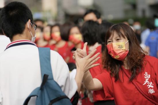 6月7日,在北京市陈经纶中学考点外,送考老师(右)为即将进入考点的考生加油鼓劲。新华社记者 鞠焕宗 摄