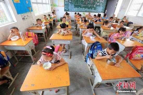 资料图:广西一小学学生在教室吃免费午餐。谭凯兴 摄