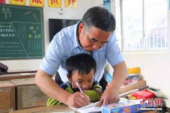 杨少成耐心教学生写字。梁俊 摄