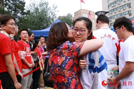 2019年高考首日,家长深情拥抱即将进入中国人民大学附属中学考点的孩子。 卢静摄