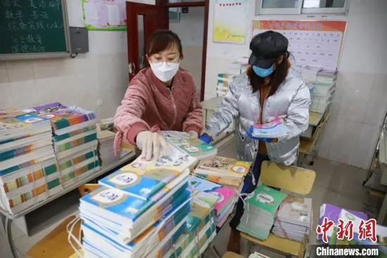 资料图:老师们分类整理新学期教材。 李捷 摄