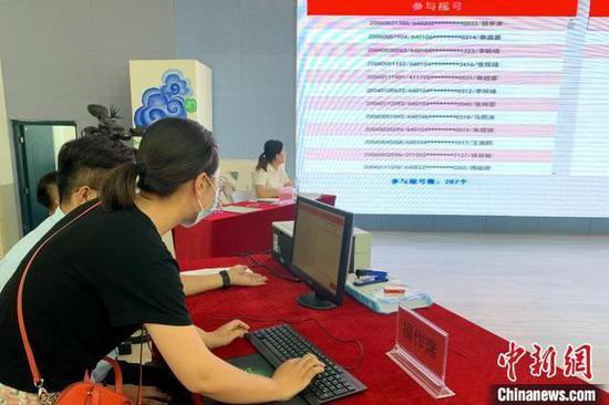家长代表现场操作摇号系统。 李佩珊 摄