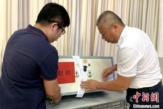 工作人员将已产生的名单封存。 李佩珊 摄