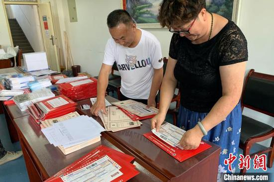 邮局工作人员为录取通知书粘贴邮寄单。 李佩珊 摄