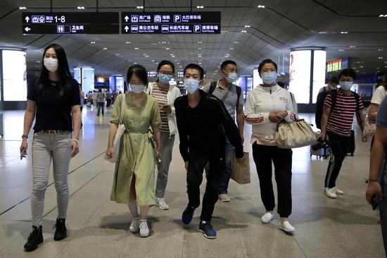 王唯佳与父母在辅导员老师的带领下前往校车接送点。 新京报记者 郑新冾摄