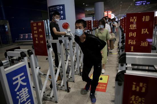 王唯佳一行走过测温通道。 新京报记者 郑新冾 摄