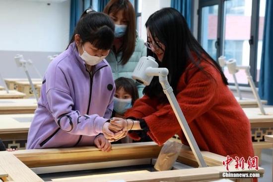 资料图:小朋友们在河北雄安容和乐民小学沙画教室体验沙画创作。 中新社记者 韩冰 摄