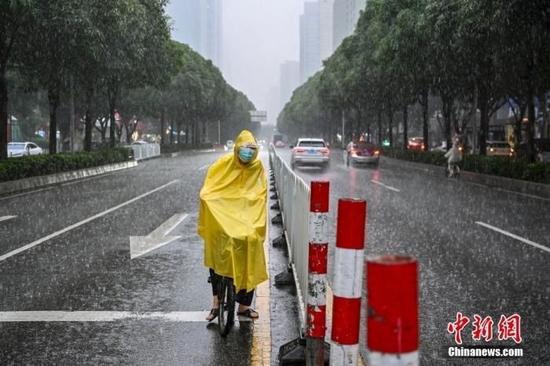 资料图:5月12日,广州市民雨中出行。中新社记者 陈骥旻 摄