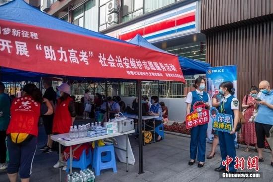 6月7日上午,2022年全国高考拉开帷幕。四川省成都市玉林中学考点考生陆续抵达和进入考点。图为社区在考点外专门设立了服务考生处。 刘忠俊 摄