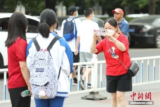 6月7日,北京市朝阳区,在北京工业大学附属中学考点,考生与家长合影留念。当日,2022年全国高考拉开帷幕。 中新社记者 蒋启明 摄