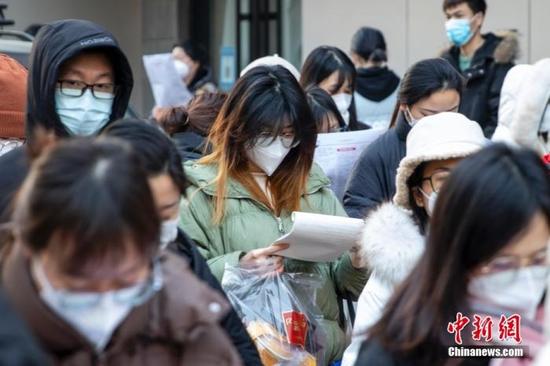 1月8日,郑州,河南省商务中等职业学校考点外,考生入场前复习。中新社发 程航 摄