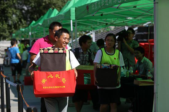 2013年8月31日,北京大学,一名大一新生在北大迎新“绿色通道”内领到了爱心礼包。视觉中国供图