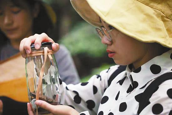 一学生在观察刚刚捕捉到的昆虫。浙江农林大学宣传部供图
