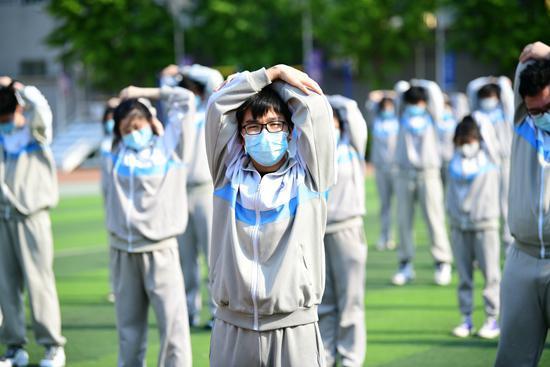 4月27日,北京高三复课首日,北京科大附中。下午课后半小时户外运动,学生们也全程佩戴口罩。视觉中国供图
