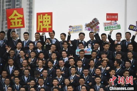 学生们在拍摄毕业照时展示创意标语。 韩苏原 摄