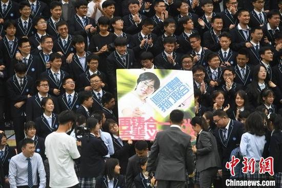 学生们在拍摄毕业照时展示创意标语。 韩苏原 摄