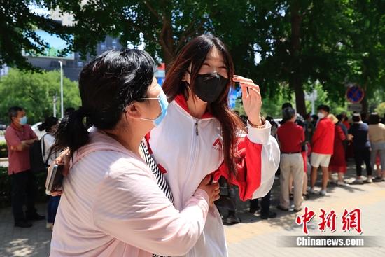 7日中午,语文考试结束后,中国人民大学附属中学考点外的考生。 中新社记者 韩海丹 摄