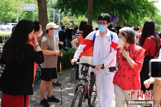 7日中午,语文考试结束后,中国人民大学附属中学考点外的考生。 中新社记者 韩海丹 摄