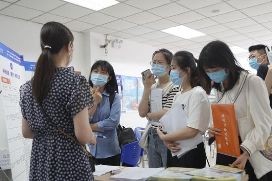 2022年5月13日,在位于重庆市北碚区的西南大学,应届毕业生在“百万英才兴重庆”招聘会上了解招聘信息。新华社记者 秦廷富 摄