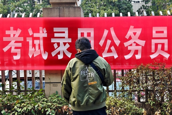 ↑2023年2月25日,武汉技师学院考点,参加公务员考试的考生等待进入考点