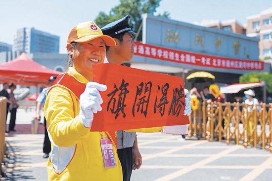 6月8日,潞河中学考点,文明引导员高举手写祝福语。