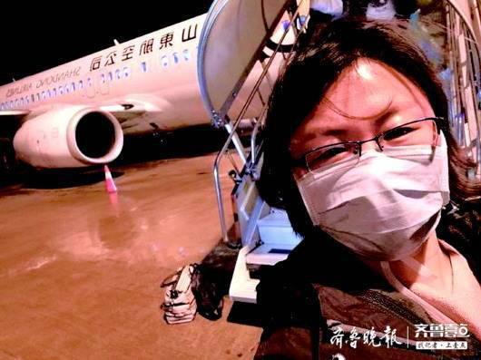 1月25日,山东首批医疗队落地湖北后,李颖霞在飞机前留下一张自拍照。