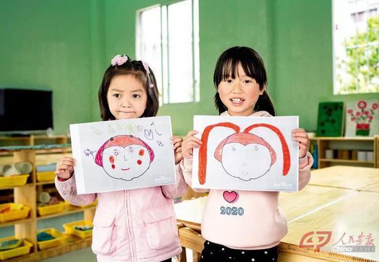 松桃苗族自治县蓼皋街道团山幼儿园,小朋友展示她们在幼儿园里画的绘画作品。