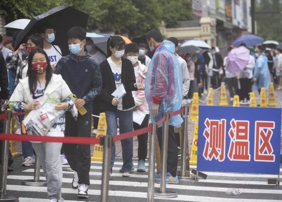 ▲6月25日,在哈尔滨市第七十二中学考点,考生测温后进入考场。图/新华社