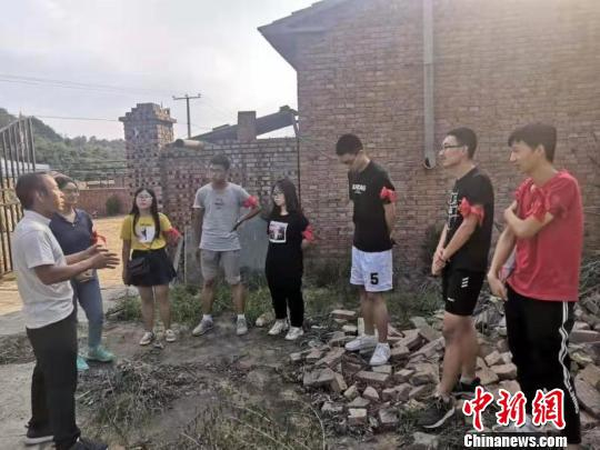 大学实习生仔细地听张杰讲解着农作物的特点和培育方法。 秦超 摄