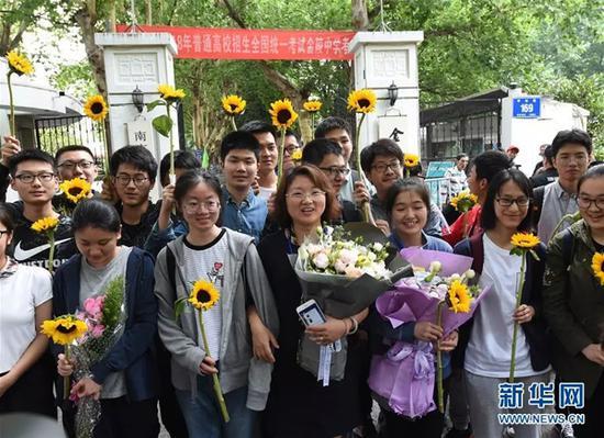 6月9日,在南京金陵中学考点门前,考生在考试结束后与送考老师(中)合影。 本文图片均来自新华网