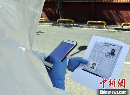 投递员按照流程正在核对收件人的身份证和准考证信息。 陈岩 摄