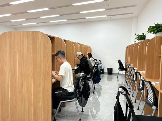 中午十二点左右,一半的学生已经外出就餐了,他们在桌面上摆好考研材料占座