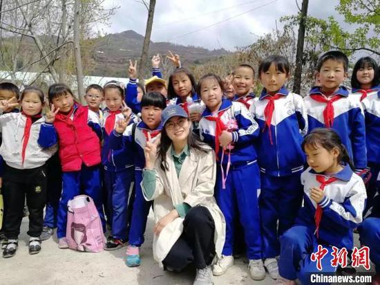 图为兰州大学第20届研究生支教团成员吕孟凡与孩子们合影。(资料图) 兰州大学供图