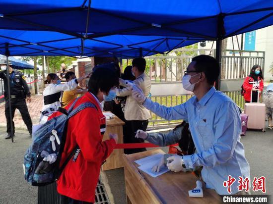 6日下午,北师大海口附属学校对返校学生测量体温。 张茜翼 摄