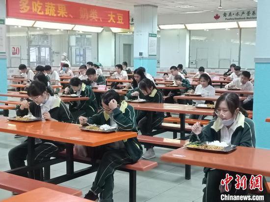海南枫叶国际学校学生就餐相隔一米以上,实行专人专座,且只能单向就坐。 张茜翼 摄
