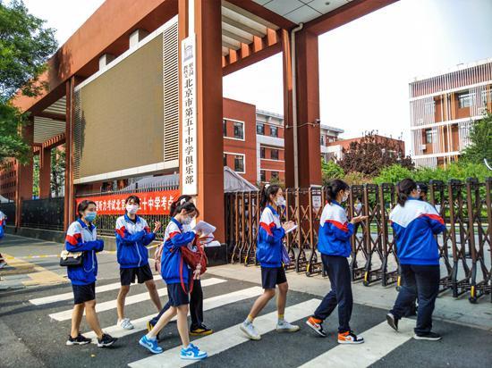 6月20日,北京,普通高考英语听力考试如期举行。在北京市第五十中学考点考生通过检测体温有序进入考场。视觉中国供图