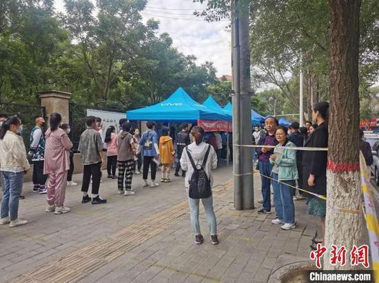 图为在西宁二中参加2020年高考的考生和在警戒线外等候的家长。 文思睿 摄