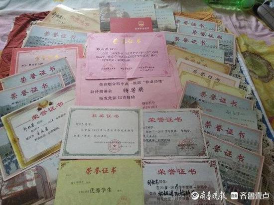 从小学到高中,邹怡芳获得的荣誉证书铺满了一床。齐鲁晚报·齐鲁壹点 记者 李楠楠 摄