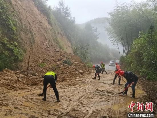 图为应急抢险队员在古田镇清理塌方泥石。 王炳尧 摄