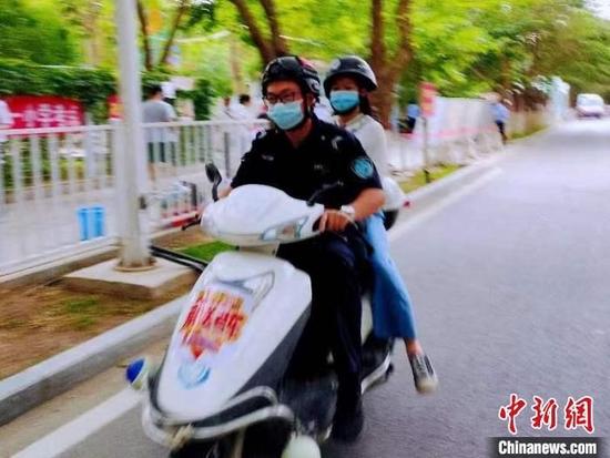 7日晨,库尔勒市民警送考场学生。 高珊珊 摄