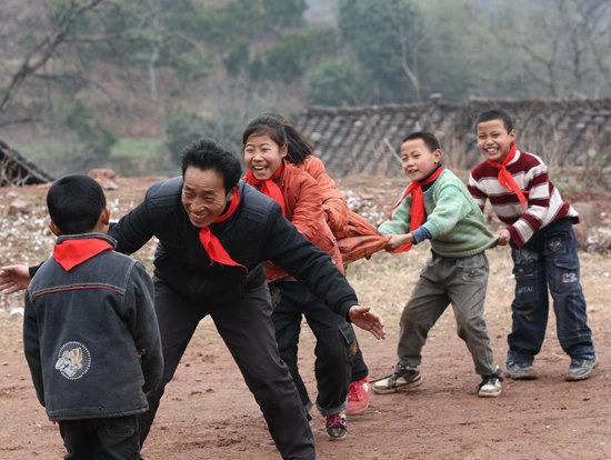 2011年2月21日,湖南湘西,泸溪县盘古岩村,符吉好老师和孩子们在玩游戏。老鹰抓小鸡是平时孩子们玩得最多的也是课余最好的玩乐方式,虽然玩了无数次,但每次都给师生们带来无限的快乐。(资料图片)视觉中国供图