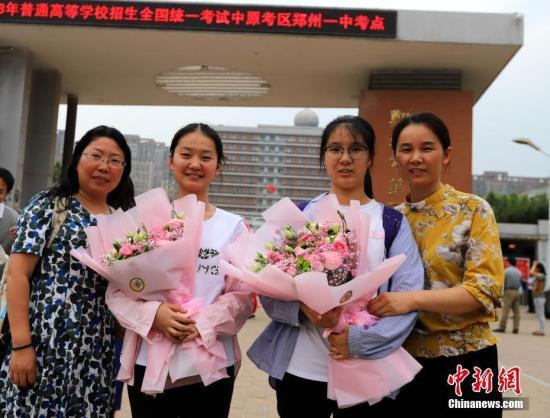 资料图:6月8日,河南郑州一高考考点外,家长向考生送上鲜花庆祝考试结束。当日,全国部分地区2018年高考结束。 中新社记者 王中举 摄
