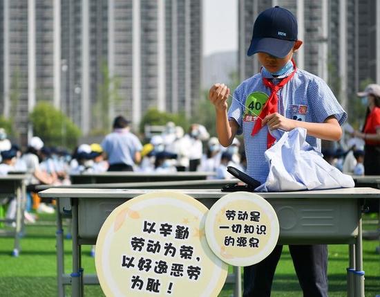 2022年5月7日,西安市后宰门小学的学生参加缝扣子比赛。新华社记者 张博文 摄