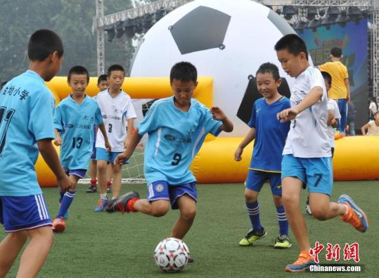 7月1日,在河北石家庄22中操场上,当地多所学校的1000余名青少年,在此体验桌上足球PK、蒙眼射门等多种足球游戏,乐享丰富多彩的校园“足球嘉年华”。据了解,此次足球主题乐园由该市教育局等主办,旨在让足球走进校园、走进生活,为青少年打造一场校园足球的文化狂欢盛宴。 <a  href='http://www.chinanews.com/'>中新社</a>记者 翟羽佳 摄